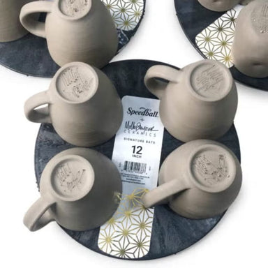 12-inch black round plastic pottery wheel bat with clay coffee mugs on top