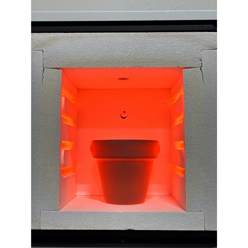 Straight-on view inside of open  HS-7GV Vitrigraph Glass kiln from Hot Shot showing a glowing-hot flower pot inside the chamber.