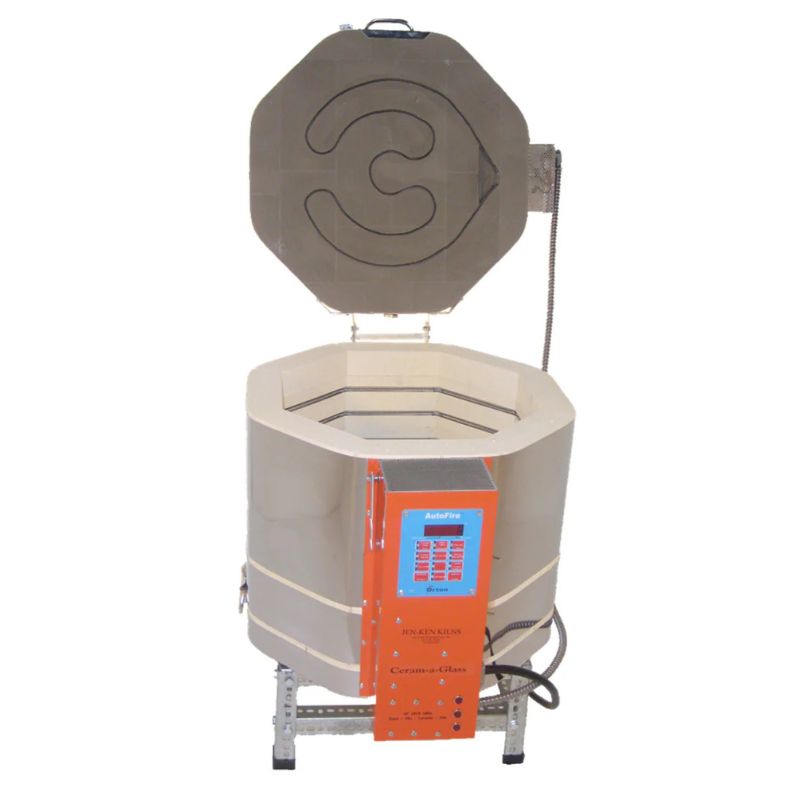 Straight-on view of opened, round-shaped AF dual-media Ceram-A-Glass 1815 ceramics and glass kiln from Jen-Ken, sitting on a small metal stand, showing the electrical box with Orton AutoFire 4000 12-button controller.