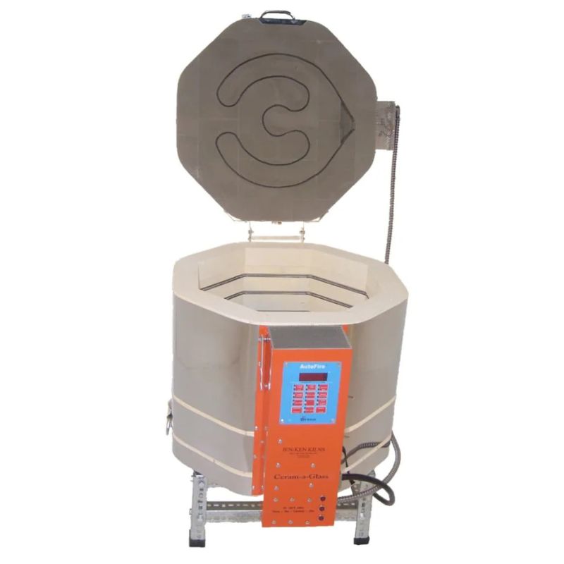Straight-on view of opened, round-shaped AFG 1815 glass - casting kiln from Jen-Ken, set on a small metal stand showing the electrical box with Orton AutoFire 4000 12-button controller.