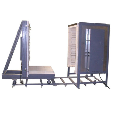 Side view image of an opened large capacity car kiln from Olympic Kilns, representative of a 64-cubic foot capacity, with floor and front door wheeled down 6-foot track to the left and an attached electrical box on the right side of the kiln.